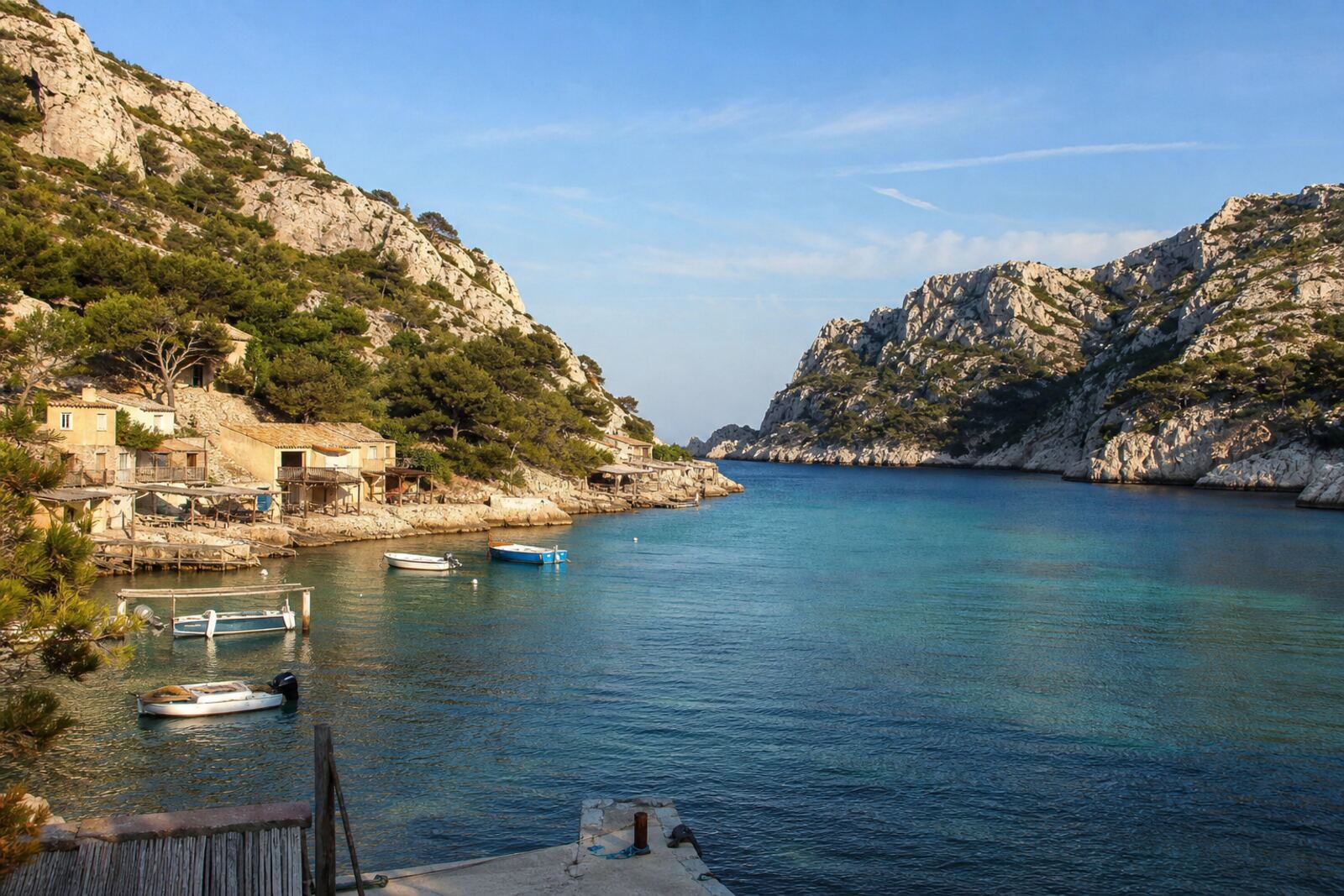 Illustration de la calanque de Sormiou : l’eau turquoise entre les falaises, cabanons au bord de l’eau